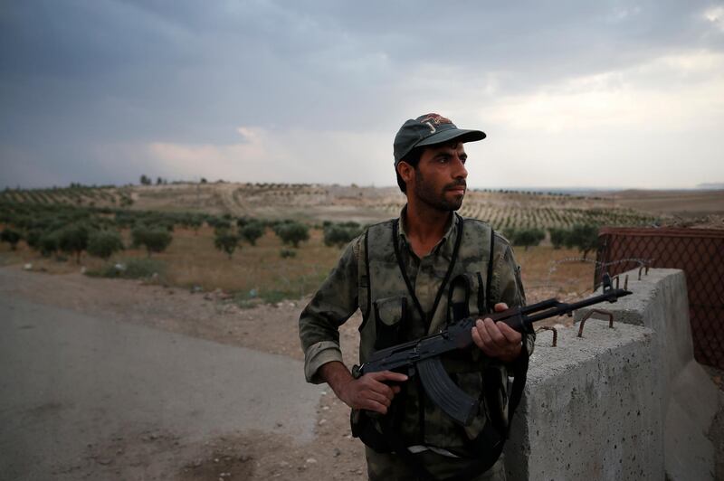 A Syrian security officer mans a checkpoint on the outskirts of Jarablus, northern Syria, Wednesday, May 30, 2018. Life is coming back to Jarablus, the Syrian city on the west side of the Euphrates River, liberated by Turkey-backed fighters in 2016 after two years under the Islamic State group control. (AP Photo/Lefteris Pitarakis)