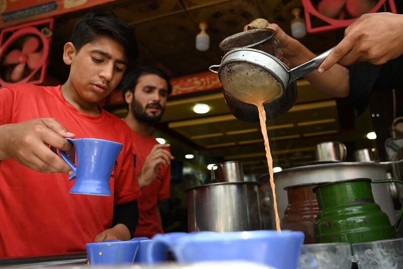 Waiters prepare to serve tea to customers at a restaurant in Islamabad. AFP