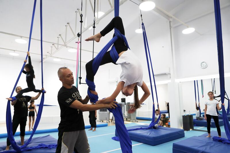 Dubai Circus School trainer Mario Mira helps a student during an aerial silks class. All photos: Pawan Singh / The National