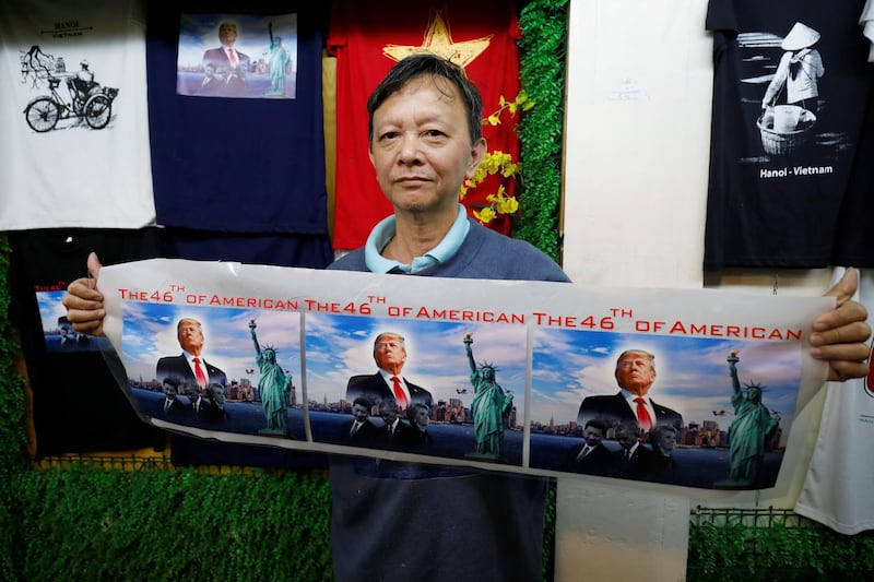Vietnamese souvenir seller Truong Thanh Duc, supporter of US President Donald Trump, shows images of the president at his shop in Hanoi, Vietnam. Reuters