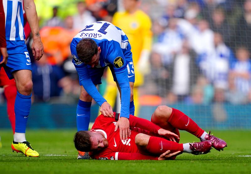Liverpool's Alexis Mac Allister lies injured after being fouled by Brighton's Pascal Gros, who received a yellow card. PA 