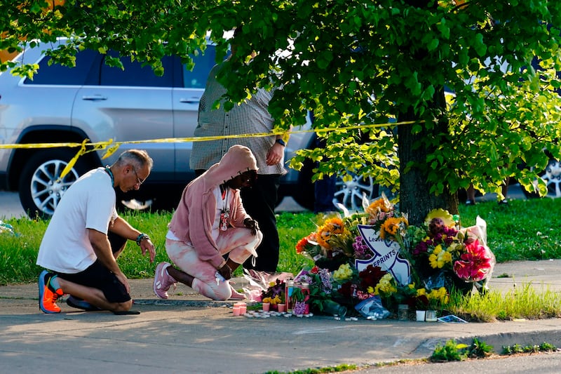 People pay their respects outside the supermarket. AP