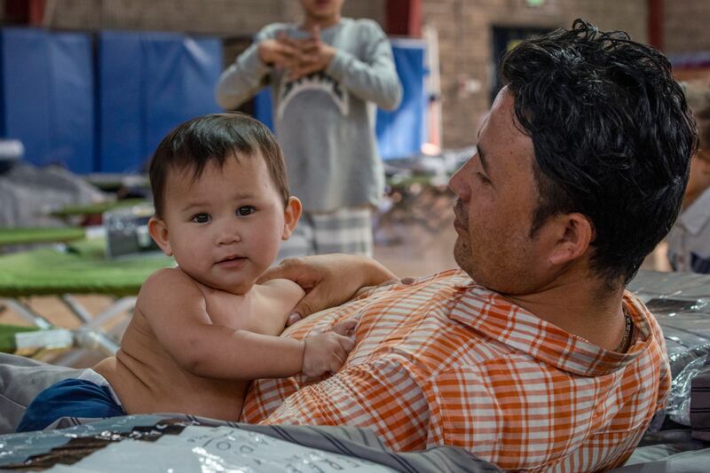A man from Afghanistan with his son at an undisclosed location in the Middle East after being flown out of Kabul. AP
