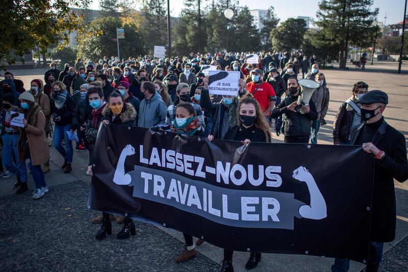 Protesters hold a banner reading "let us work" as hundreds of workers protest against the sanitary measures in Nantes, western France. AFP