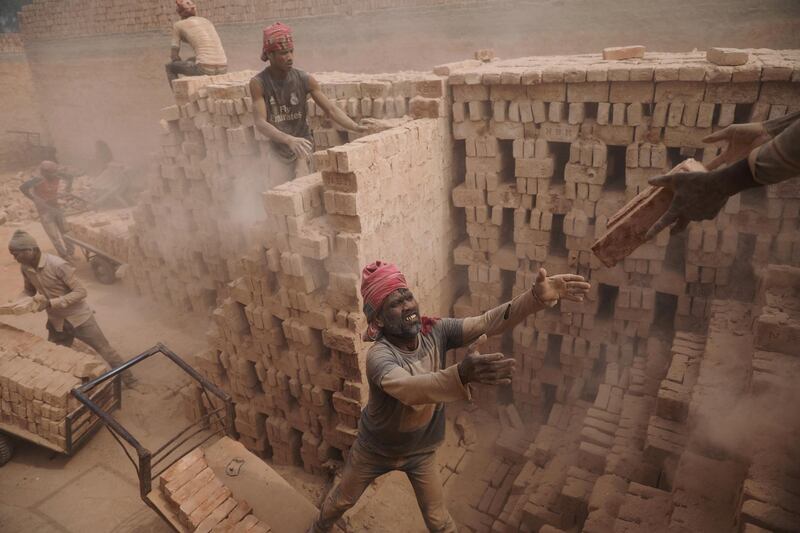 Brick factory workers stack bricks on a cart to take them to the warehouse in Dhaka, Bangladesh. Mohammad Ponir Hossain / Reuters