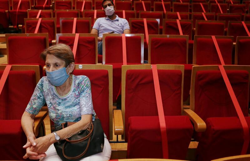 A woman wearing a protective mask sits in compliance with social-distancing rules as she attends the Syrian National Symphony Orchestra at the Opera House in Damascus, Syria. Reuters