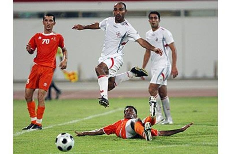 Sharjah's Abdullah Suhail, centre, hurdles an Ajman challenge during a pre-season friendly.