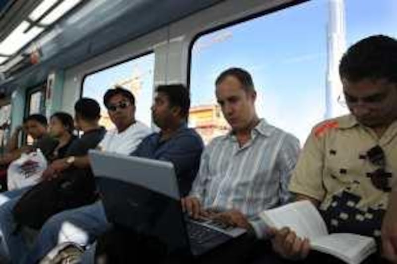 DUBAI . 1st October. 2009. COMMUTERS ON METRO. Architect Christopher Gintner at work on his laptop aboard the Dubai Metro as he travels to his office in Diera along with other commuters.  Stephen Lock  /  The National. FOR SATURDAY PAPER *** Local Caption ***  SL-commuter-001.jpg