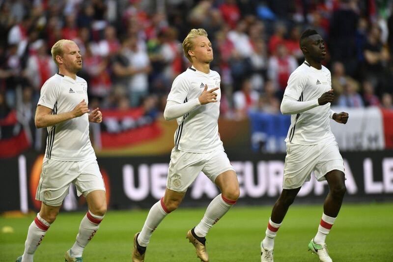 Ajax players Kasper Dolberg, centre, and Davy Klaassen, left, and Davinson Sanchez, right, warm up before the Europa League final. Peter Powell / EPA