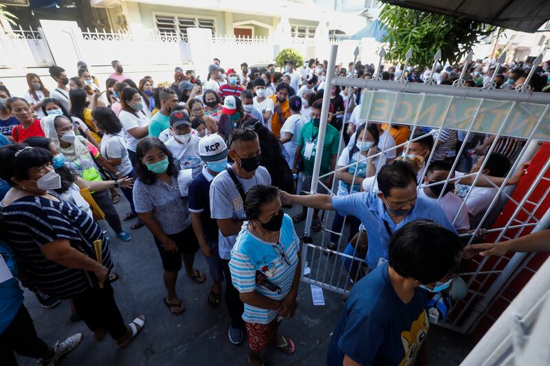 People wait their turn to enter a school being used as a voting centre. EPA
