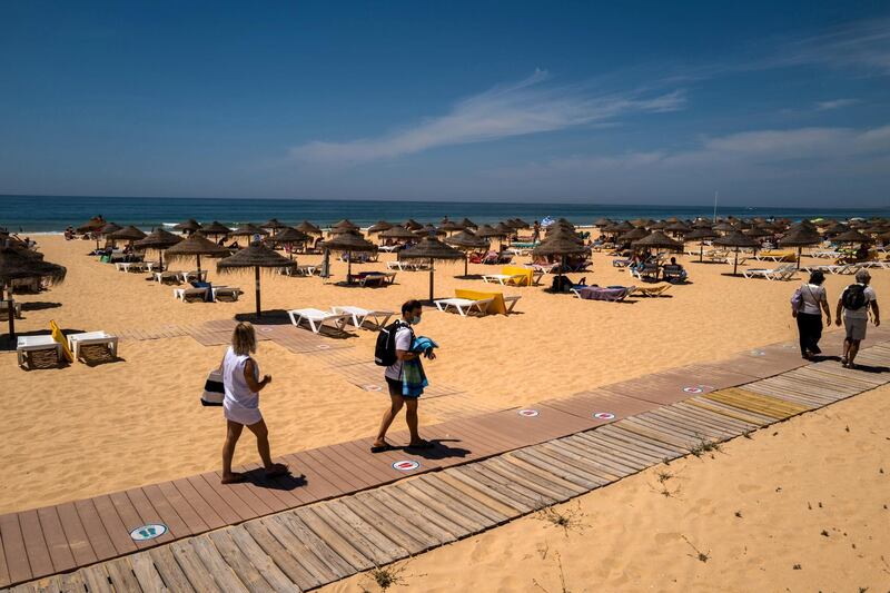 Beachgoers make their way onto the sand at Falesia Beach in Vilamoura, Portugal, on Sunday, May 30, 2021. Portugal is likely to raise its economic growth forecast for this year to close to 5% as tourists help boost the recovery and Europe’s Covid-19 vaccination campaign advances. Photographer: Jose Sarmento Matos/Bloomberg