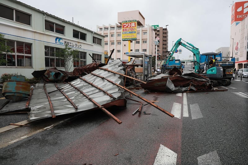 A clean-up crew works to remove roofs which were blown off into a street by strong winds brought by Typhoon Haishen in Fukuoka as the storm passes the southern Japanese island of Kyushu.   AFP