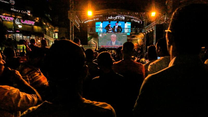 Palestinians watch Palestinian president Mahmoud Abbas on a large screen in the West Bank city of Ramallah. AFP