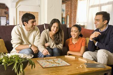 Having a board game or movie night with friends and family is a free alternative to more expensive social excursions. Photo: Getty Images