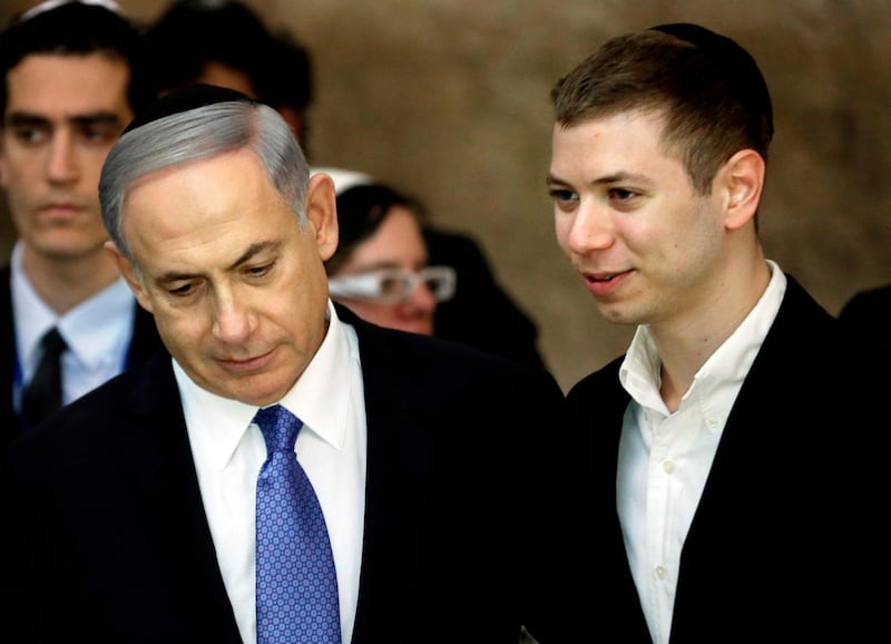(FILES) This file photo taken on March 18, 2015 shows Israeli Prime Minister Benjamin Netanyahu (L) and his son Yair visiting the Wailing Wall in Jerusalem.
The Israeli premier's son has been caught on tape seemingly drunk outside a strip club talking about a key natural gas deal, leading to political fallout on January 9, 2018.
On the recording, which was aired by Israel's Channel 2 television late on January 8 and is said to be from 2015, the 26-year-old can be heard speaking with the son of Kobi Maimon, a stakeholder in the company that owns a share in Israel's offshore Tamar gas field.
 / AFP PHOTO / THOMAS COEX