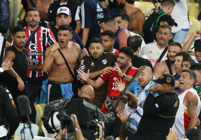 Fans clash in the stands with security staff causing a delay to the start of the match. Reuters