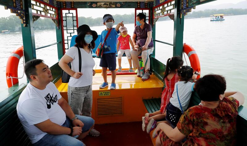 People ride a boat on a lake in the park at Summer Palace on a public holiday, in Beijing, China. Reuters