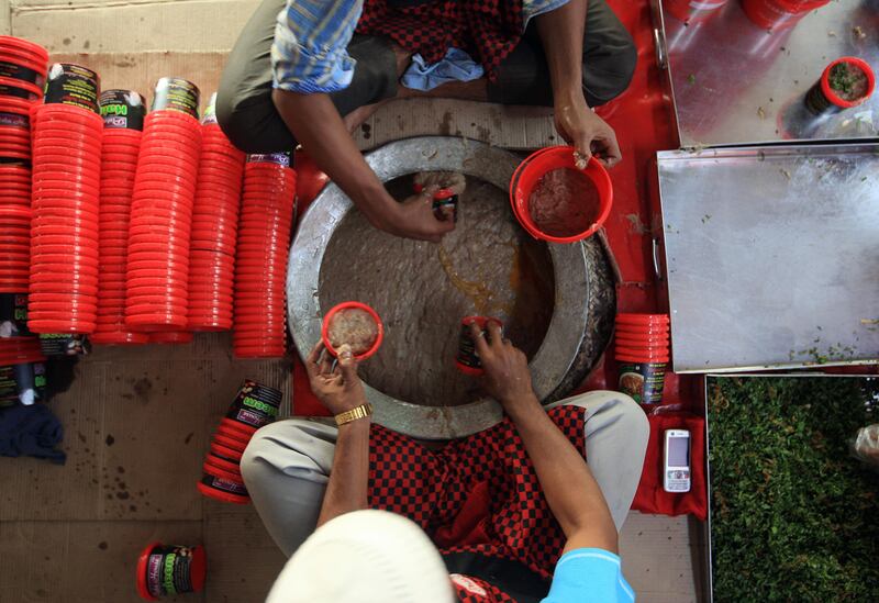 HYDERABAD - INDIA - 01AUG 2012 -  Workers filling Haleem to containers at Pista house, which received a geographical indicator trademark for its haleem, a dish of meat and lentils that it makes particularly during Ramadan on Charminar road in Old Hyderabad City in Andhra Pradesh State in India.  The haleem prepared here is so popular that it is even sent out by post, in response to orders received from across India. Ravindranath K / The National (to go with Samanth story on Ramadan)
