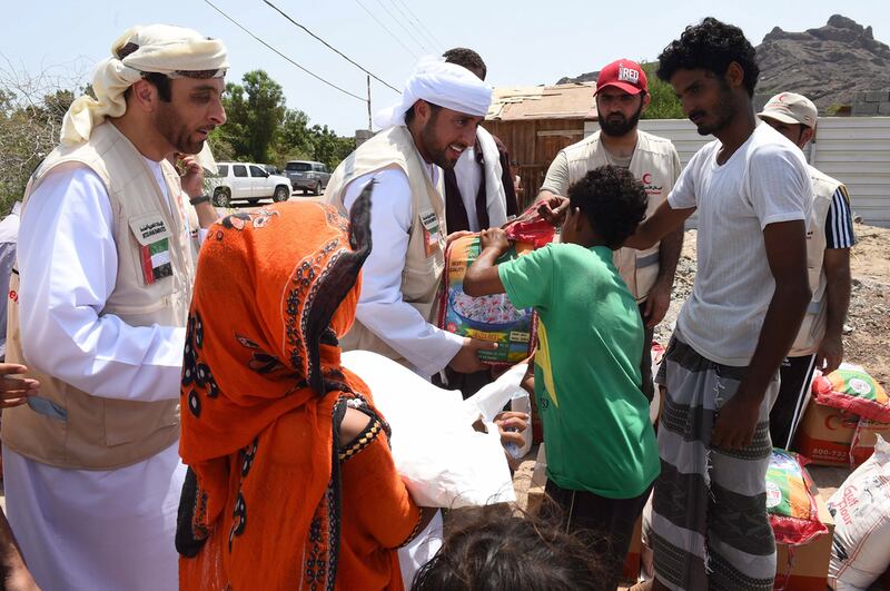 Volunteers from the Emirates Red Crescent delegation distribute aid to people affected by the humanitarian crisis in Yemen. Wam