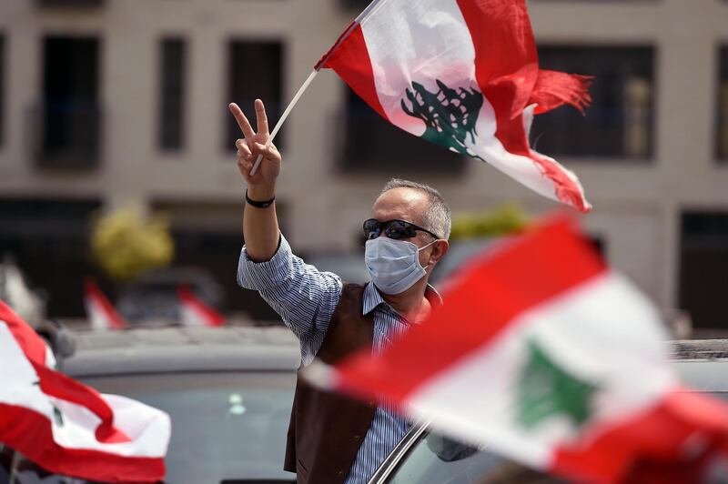 An anti-government protester waves a national flag during a parade to protest the economic situation in downtown Beirut, Lebanon.  EPA