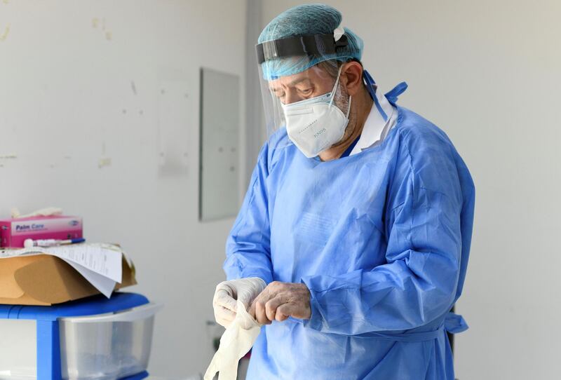 Abu Dhabi, United Arab Emirates - Medical staff prepares himself before testing the patients at Advanced Centre for Daycare Surgery. Khushnum Bhandari for The National
