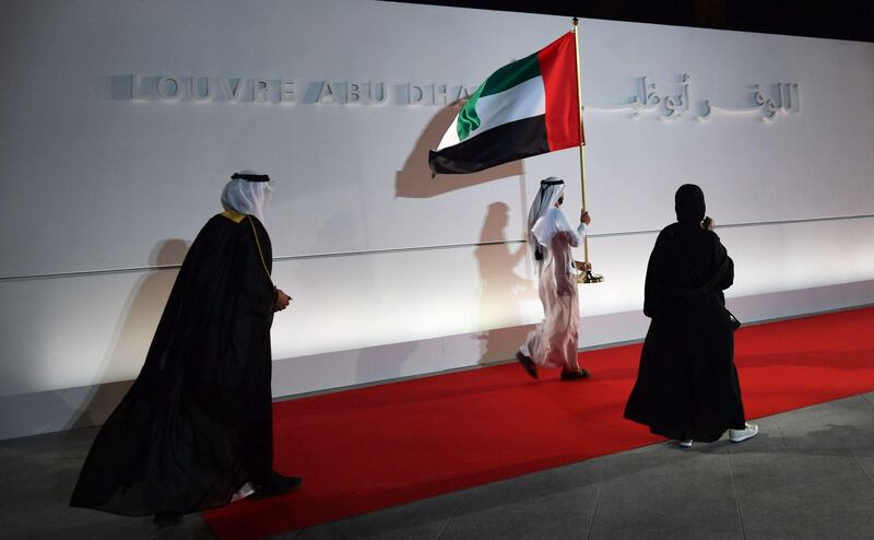 An Emirari man carrying the UAE national flag at the entrance ofLouvre Abu Dhabi. Giuseppe Cacace / AFP Photo
