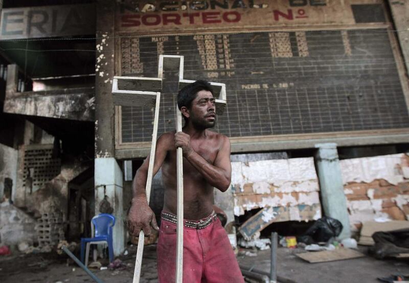 A resident, living in building damaged by a previous earthquake in 1972, carries a cross as he leaves the building after an earthquake shook Managua. Oswaldo Rivas / Reuters