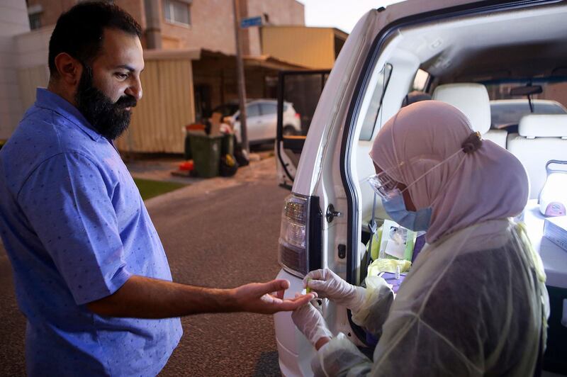 A Kuwaiti health ministry worker conducts a random test for the novel coronavirus in Kuwait City. AFP