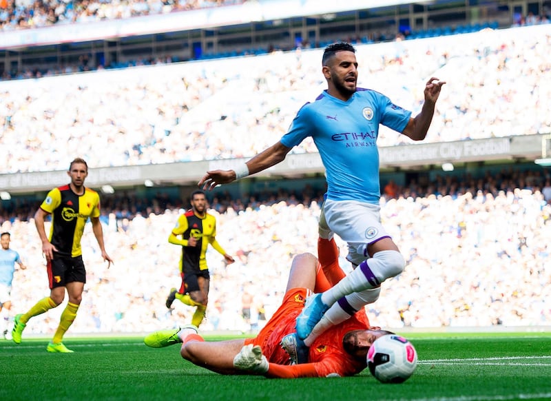 Watford goalkeeper Ben Foster (bottom) fouls Manchester City's Riyad Mahrez in the penalty box. EPA