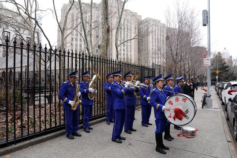 A band plays music on the sidewalk during a funeral in the Chinatown area of New York. Reuters