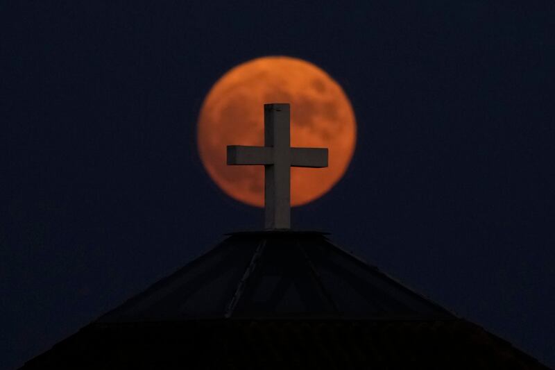 A supermoon appears behind a cross on a church dome in Nicosia, Cyprus. AP