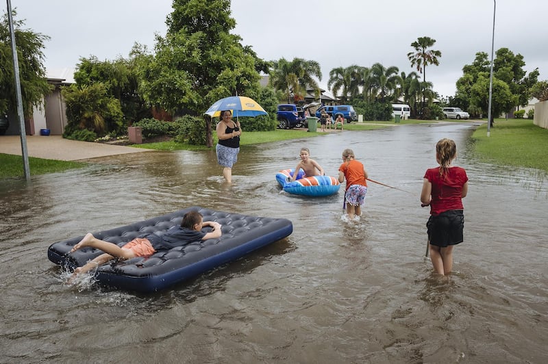 Residents of the Townsville suburb of Idalia play in floodwaters.  EPA