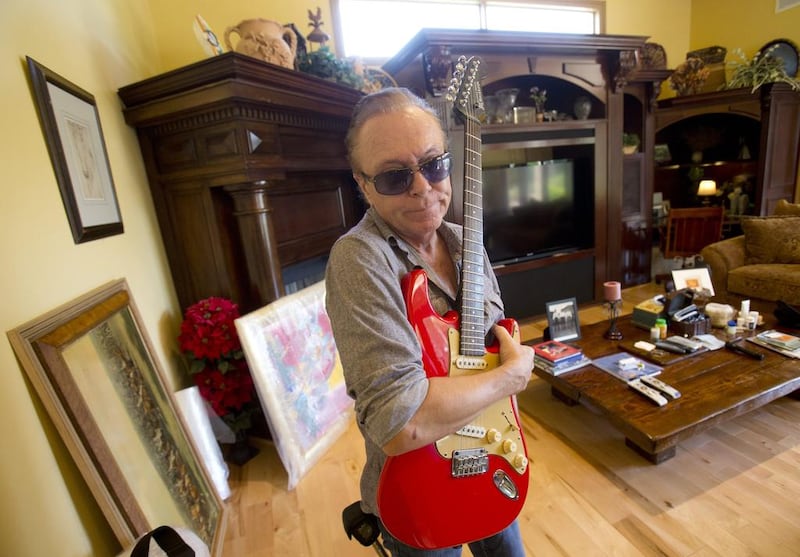 David Cassidy holds one of his favorite guitars as he gives a tour of the house. AP