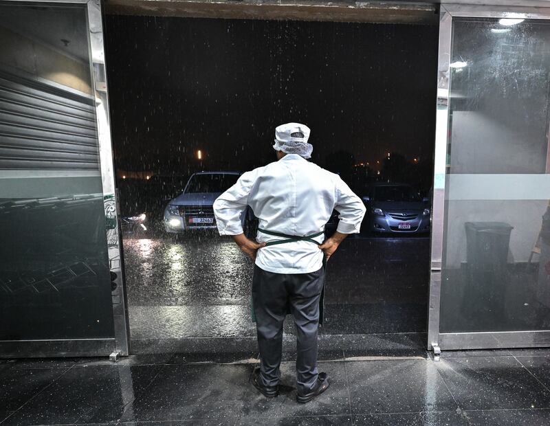 Al Fair Supermarket staff watch the strong downpour in Khalifa City, Abu Dhabi. Victor Besa / The National