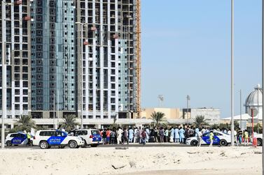 Police and labourers pictured on Reem Island on Sunday. Khushnum Bhandari / The National