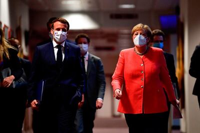 German Chancellor Angela Merkel (R) and French President Emmanuel Macron (L) arrive for a joint press conference at the end of the European summit at the EU headquarters in Brussels on July 21, 2020.  EU leaders approved a 750-billion-euro package to revive their coronavirus-ravaged economies after a tough 90-hour summit on July 21, along with a trillion-euro budget for the next seven years. / AFP / POOL / JOHN THYS
