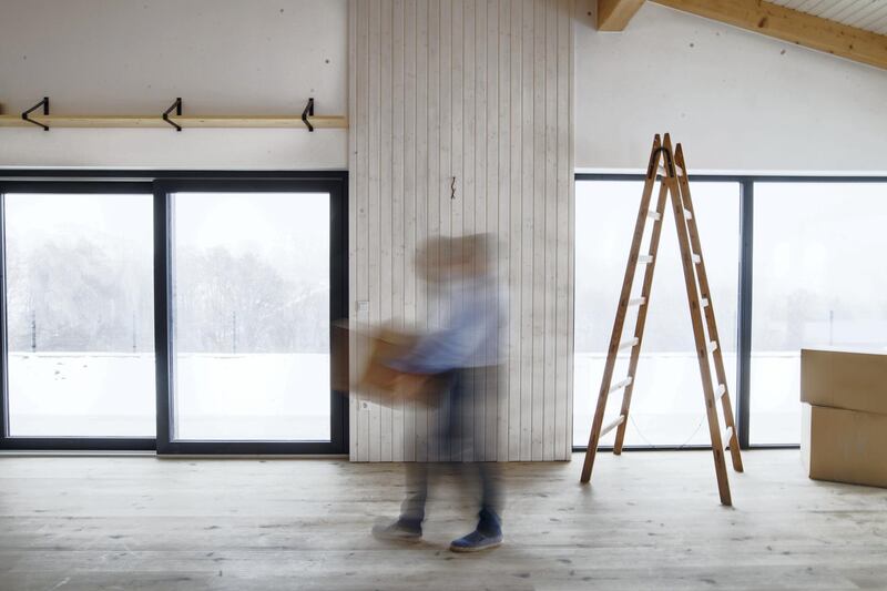 An unrecognizable man walking with cardboard boxes when furnishing new house. Intentional motion blur.