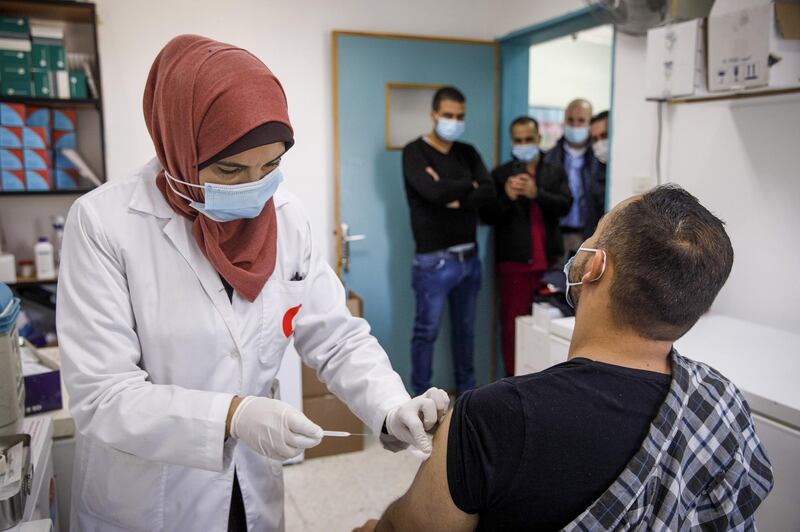A Palestinian nurse administers a dose of the Moderna Inc. Covid-19 vaccine to a health worker inside a health center in Bethlehem, West Bank, on Sunday, Feb. 7, 2021. The Palestinian Ministry of Health started its Covid-19 vaccine campaign, with health care workers being the first to receive shots. Photographer: Kobi Wolf/Bloomberg