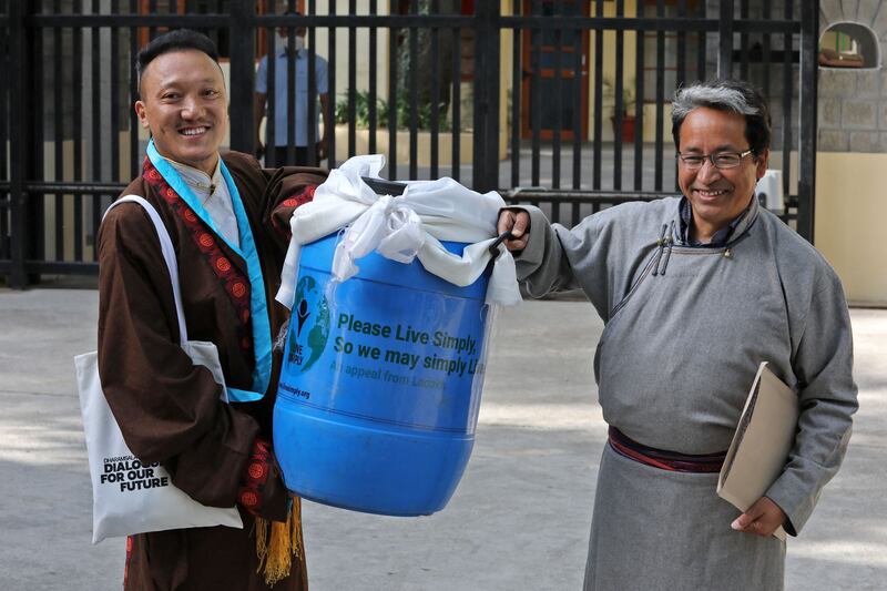 India's climate activist Sonam Wangchuk, right, carries a container with a block of ice from the Khardung La glacier to  Tibetan spiritual leader the Dalai Lama at Tsuglakhang in McLeod Ganj. AFP