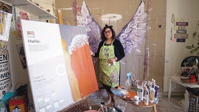 Saudi artist Maha Musalli stands beside her exhibited canvas, of which only 47.6 per cent is painted. Courtesy Standard Chartered 