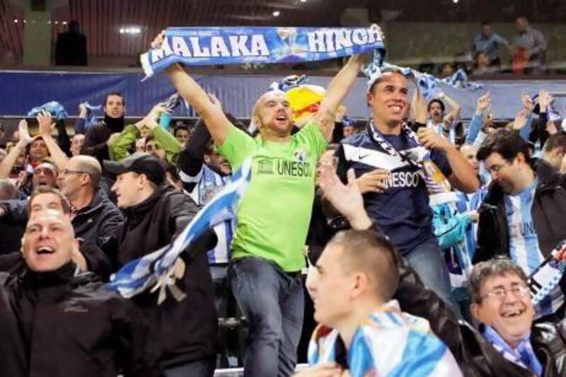 Malaga supporters celebrate during the Champions League group stage match with Anderlecht. The on-field success has been dampened by the off-field issues with Uefa over the Financial Fair  Play rules and the Spanish government over tax payments.