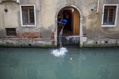 A worker clears a house from excess water left by recent flooding in Venice, Italy, on Wednesday, Nov. 20, 2019. Two weeks after high tides and fierce winds produced the worst flooding in Venice in more than half a century, sirens sound about 6:30 a.m. to warn the fragile lagoon city’s weary residents that “acqua alta” is arriving again. Photographer: Geraldine Hope Ghelli/Bloomberg