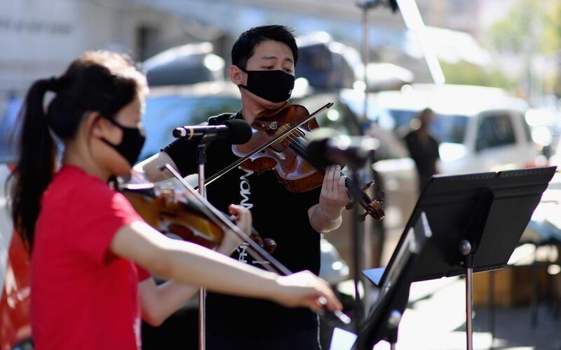 Violinist Quan Ge (L) and violist Cong Wu of the New York Philharmonic play with their 'bandwagon's pop-up concert series' at Betty Carter Park. AFP