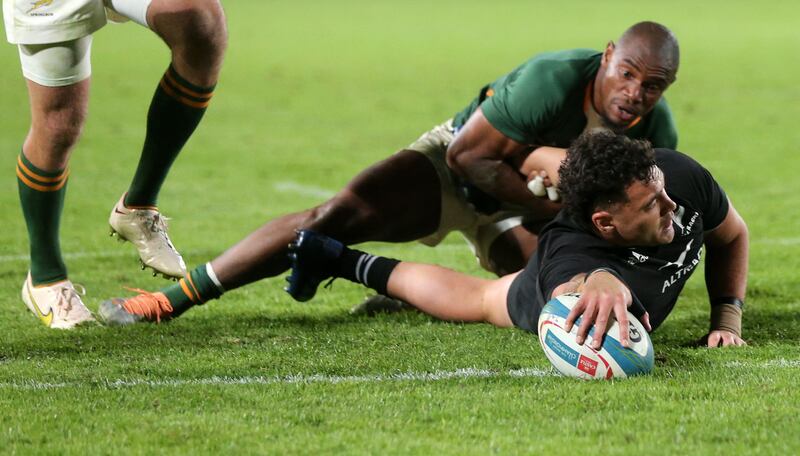New Zealand's centre David Havili (FRONT) is tackled by South Africa's wing Makazole Mapimpi as he scores a try during the Rugby Championship international rugby match between South Africa and New Zealand at Emirates Airline Park in Johannesburg on August 13, 2022.  (Photo by PHILL MAGAKOE  /  AFP)