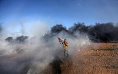 epa06941584 A Palestinian protester covers his face from Israeli tear-gas during clashes with Israeli troops near the border with Israel in the east of Gaza City, 10 August 2018. Two Palestinians protesters were shot dead and more than 240 other got injured during the clashes after Friday protests between Israeli troops and Palestinians protesters near the border eastern Gaza Strip. Protesters plan to call for the rights of Palestinian refugees across the Middle East to return to their homes that they fled in the war surrounding the 1948 creation of Israel.  EPA/HAITHAM IMAD