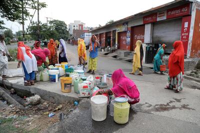 epa08420864 Indian migrant women laborers collect water from a roadside tab during a lockdown to combat the spread of the coronavirus disease (COVID-19) pandemic in Jammu, India, 14 May 2020. Prime Minister of India Narendra Modi has announced a 266 billion US dollar stimulus package in an effort to boost India's economy after it was negativity impacted by the coronavirus outbreak. The dollar value of the rescue package is larger than the gross domestic product (GDP) of 149 countries.  EPA/JAIPAL SINGH