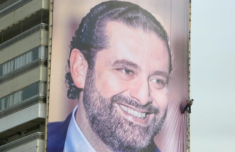 A worker is seen fixing a huge banner depicting Lebanese prime minister Saad al-Hariri, who resigned a fortnight ago during a visit to Saudi Arabia, in the southern city of Sidon, Lebanon, November 18, 2017. REUTERS/Ali Hashisho