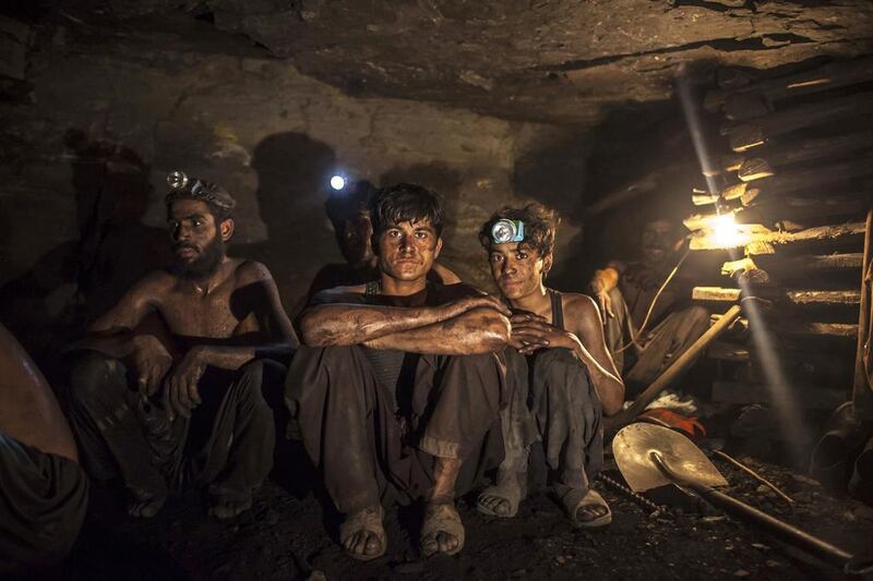 Miners pose for a photograph at the coal face inside a mine in Choa Saidan Shah, Punjab. Sara Farid / Reuters