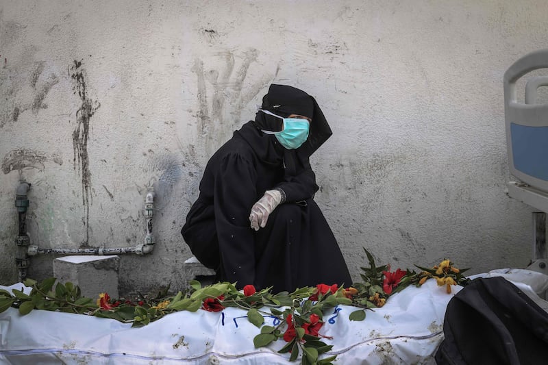 A woman mourns near a body unearthed at Nasser Hospital in Khan Younis in southern Gaza. AFP