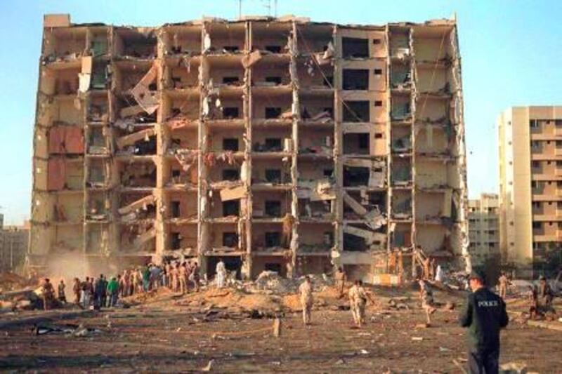 Workers stand beside the crater Wednesday, June 26, 1996 after a deadly truck bomb exploded at a U.S. military facility in Dhahran, Saudi Arabia. The blast occured at Khobar Towers which houses U.S. servicemen based at Abdul Aziz Air Base and has killed at least 19 and injured hundreds. (AP Photo/U.S. Navy)